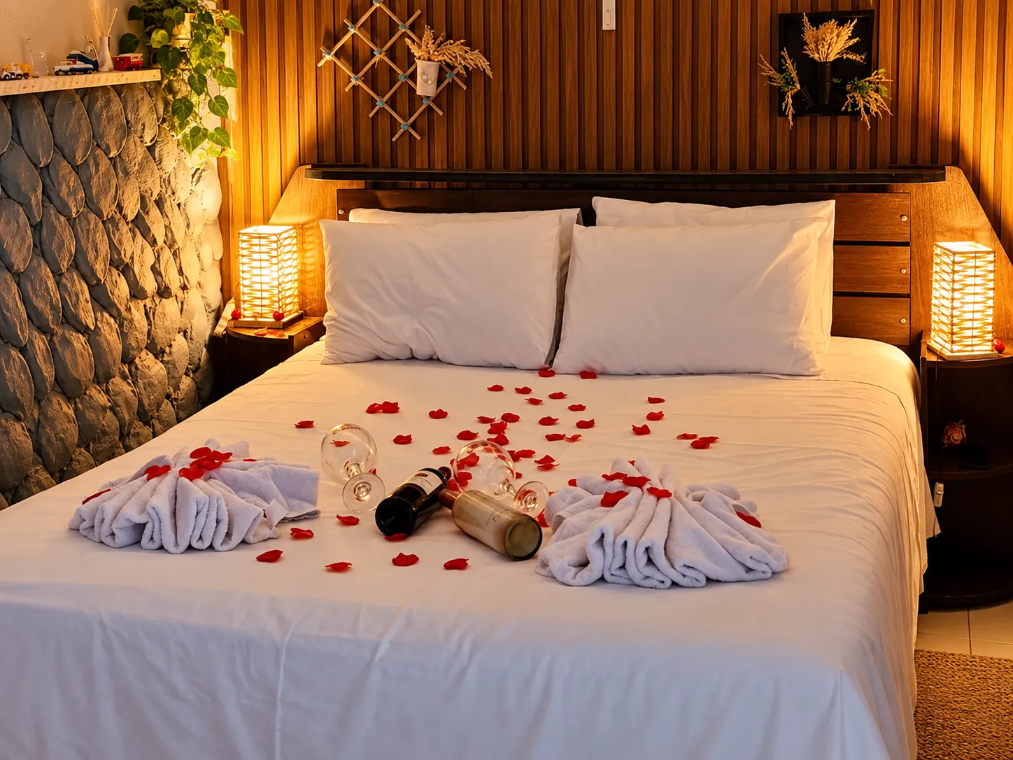 Cama preparada com pétalas, toalhas e luz quente